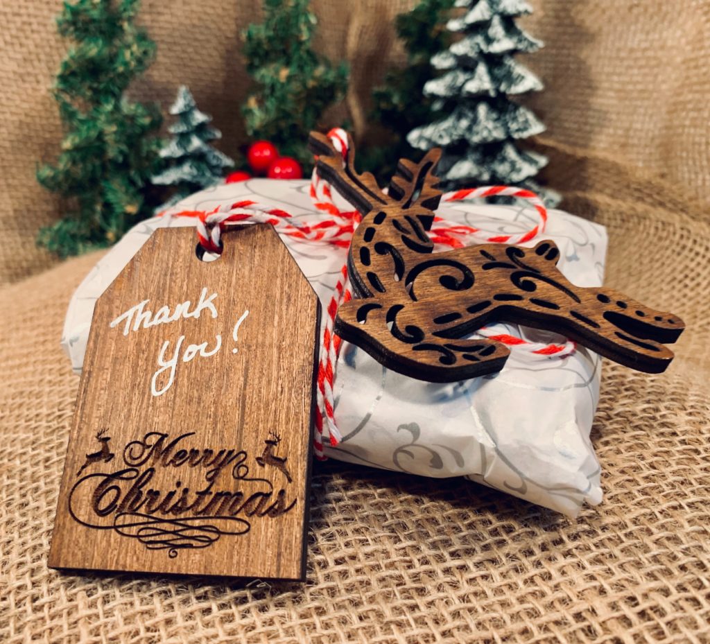 Decorative wooden gift tag tied to a small Christmas present